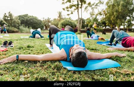 Primo piano donna anziana che fa attività di allenamento con un gruppo di amici in un parco pubblico - Salute anziani stile di vita Foto Stock