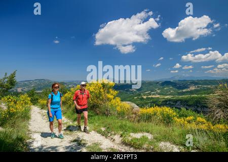 Escursioni uomo e donna attraverso la gola fiorita, Grande Anello dei Sibillini, Monti Sibillini, Parco Nazionale Monti Sibillini, Parco Foto Stock