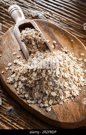 Avena arrotolata sul tagliere di legno Foto Stock