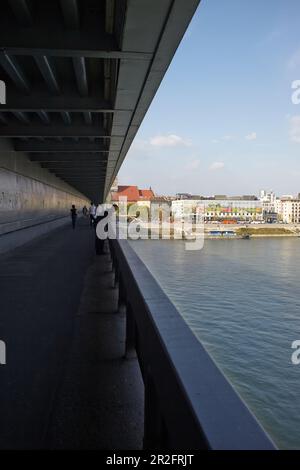 Passeggiata sul ponte della rivolta nazionale slovacca (slovacco ufficialmente la maggior parte SNP) con Danubio e le facciate delle case, Bratislava, Slovacchia Foto Stock