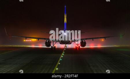 Airbus A320 di notte e nebbia di fronte alla pista all'aeroporto di Monaco, Baviera, Germania Foto Stock