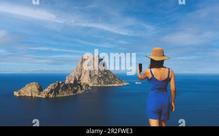 Donna asiatica selfie di fronte all'isolotto di es Vedra in Spagna sul mare in estate a Cala dhort Foto Stock