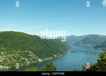 Aerail Vista su Lugano con Lago alpino e montagna in una giornata di sole in Ticino, Svizzera Foto Stock