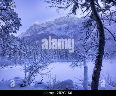 Vista sul lago ghiacciato fino all'Eibsee Hotel, Grainau, alta Baviera, Baviera, Germania Foto Stock