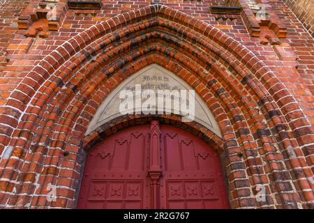 Piccola città di Waren, Chiesa di San Giorgio, basilica di mattoni, iscrizione Matteo 11, versetto 28, ingresso laterale, Arco appuntito, Mecklemburg Lake District Foto Stock