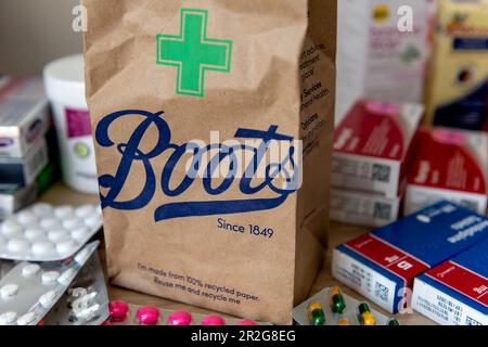 Londra. UK- 05.14.2023. Un sacchetto di carta marrone dalla farmacia e negozio di bellezza Boots con il nome della società e il simbolo della farmacia stampato davanti. Foto Stock