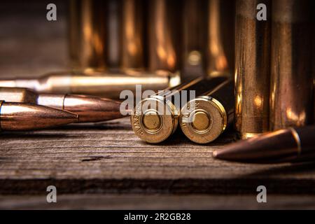 Primo piano delle cartucce del fucile calibro .308. Munizioni per armi su una superficie di legno. Sfondo scuro. Foto Stock