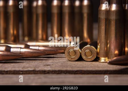 Primo piano delle cartucce del fucile calibro .308. Munizioni per armi su una superficie di legno. Sfondo scuro. Foto Stock