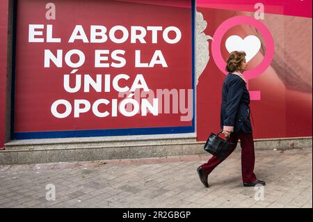 Madrid, Spagna. 19th maggio, 2023. Una donna passa davanti a un segno che legge 'l'aborto non è l'unica opzione' durante una protesta anti-aborto fuori dalla clinica Dator. La clinica Dator è una delle cliniche accreditate in Spagna per l'interruzione volontaria della gravidanza. Credit: Marcos del Mazo/Alamy Live News Foto Stock
