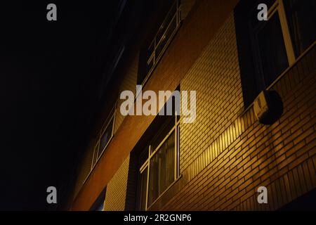 un muro di mattoni illuminato di notte Foto Stock