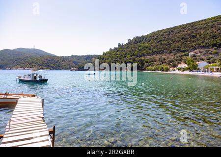 Baia di Kerveli Beach con barche da pesca e molo di legno nella parte orientale dell'isola di Samos in Grecia Foto Stock