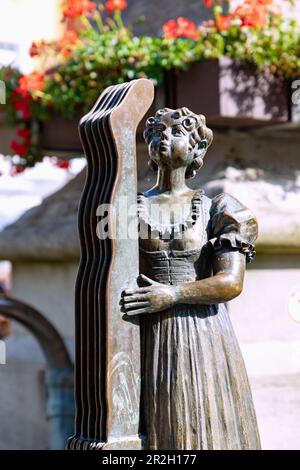 Fontana con figura bronzea della calza a Marienplatz a Immenstadt im Allgäu in Baviera in Germania Foto Stock