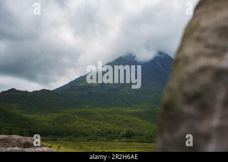 Un lussureggiante giardino in La Fortuna, Costa Rica con il Vulcano Arenal in background Foto Stock