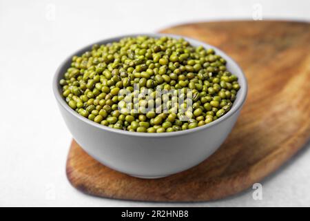 Ciotola con fagiolini verdi e asse di legno su tavolo bianco, primo piano Foto Stock