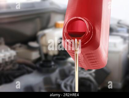 Versamento dell'olio motore dal contenitore rosso, primo piano Foto Stock