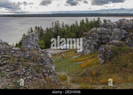 Mobile home è su una piccola strada tra formazioni rocciose. mare sullo sfondo. Larbro, Gotland, Svezia. Foto Stock