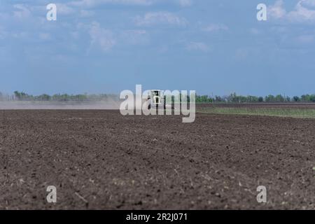 19 maggio 2023, regione di Kherson, Ucraina: Recentemente deminato campo è arato per la piantagione presso la fattoria Pershe Travnia del villaggio Velyka Oleksandrivka della regione di Kherson dopo la liberazione dall'invasione russa. L'azienda produceva cereali (grano, orzo, girasole), carne (maiale) e altri prodotti; con 100 dipendenti e più di 3.000 ettari di campi, più di 1200 suini. L'azienda è stata completamente distrutta, tutte le attrezzature, raccolto dal 2021, fertilizzanti, tutti gli edifici compresi i depositi di grano e luoghi in cui i maiali sono stati tenuti e nutriti. Dopo aver bombardato i maiali sono stati bruciati vivi, alcuni in panico saltato Foto Stock