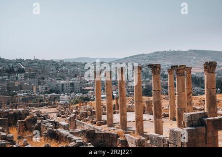 Le rovine di un tempio romano, con la città moderna di Jerash sullo sfondo, Jerash, Giordania, Medio Oriente Foto Stock