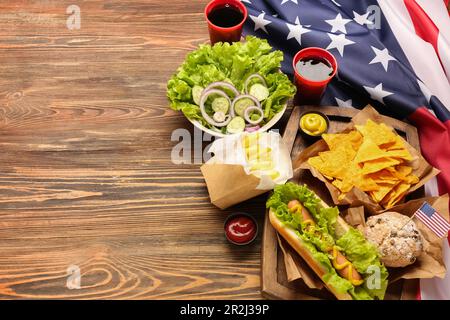 Composizione con gustosi piatti e bevande per la celebrazione del Memorial Day e bandiera americana su sfondo in legno Foto Stock