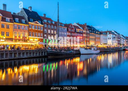 Case colorate, ristoranti e navi storiche al canale Nyhavn e porto al crepuscolo, Copenaghen, Danimarca, Europa Foto Stock
