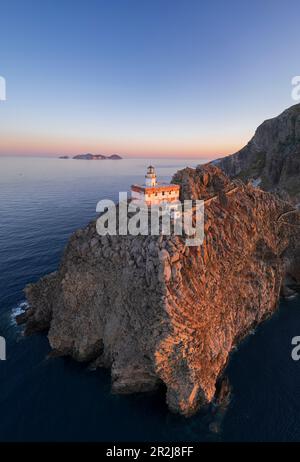 Veduta aerea panoramica del faro dell'isola di Ponza, Punta della Guardia, in cima a una scogliera che si affaccia sul mare al tramonto, sull'isola di Ponza Foto Stock