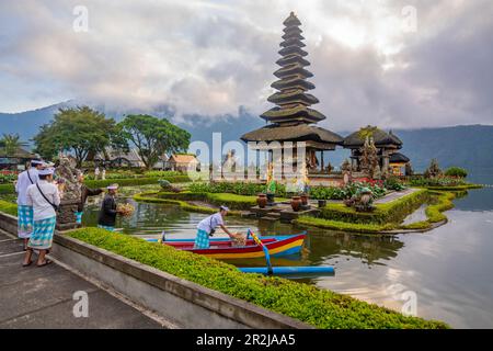 Vista delle offerte in corso al tempio Ulun Danu Beratan sul lago Bratan all'alba, Bali, Indonesia, Asia sudorientale, Asia Foto Stock