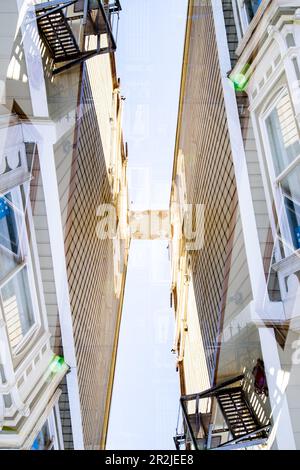 Doppia esposizione dello spazio tra due edifici residenziali in legno nel famoso quartiere della missione di San Francisco, California. Foto Stock