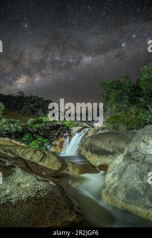 Una splendida immagine notturna delle Emerald Creek Falls attraversate dal nucleo di milkyway in una notte limpida a Mareba, Queensland, Australia. Foto Stock