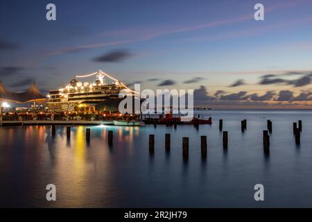 Karels Beach Bar sul molo con nave da crociera World Voyager (Nicko Cruises) al molo al crepuscolo, Kralendijk, Bonaire, Antille Olandesi, Caribe Foto Stock