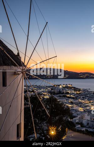 Mulino a vento di fronte al Sunset Bar a 180° che si affaccia sulla città con i famosi mulini a vento e le isole di Mykonos al crepuscolo, Mykonos, Egeo meridionale, Grecia, UE Foto Stock
