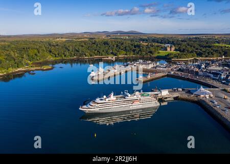 Veduta aerea della nave da crociera della spedizione World Voyager (crociere nicko) al molo con la città e il castello di Lews in lontananza, Stornoway, Lewis e Harris Foto Stock