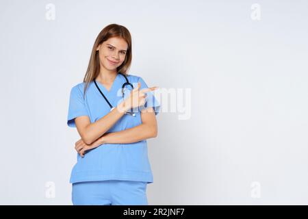 Sorridente medico donna che indica con la mano su copia spazio isolato su sfondo bianco. Foto Stock