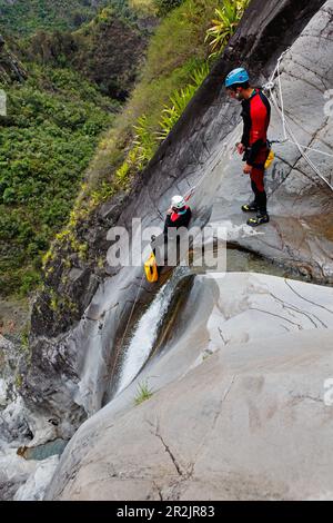 Persone canyoning al Canyon du Fleur Jaune bei Cilaos, La Reunion, Oceano Indiano Foto Stock