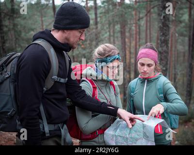 Il gruppo escursionistico legge la mappa escursionistica mentre si escursioni nella foresta nel Parco Nazionale Tiveden in Svezia Foto Stock