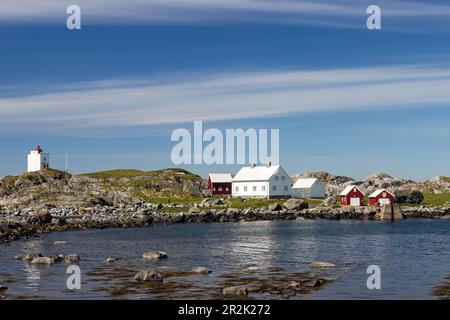 Ulla fyr (faro) eretto nel 1874 a Kvernholmen, Ulla, Haram, Sunnmøre, Norvegia. Alloggi del guardiano della casa luce a destra con boathouses rosso Foto Stock