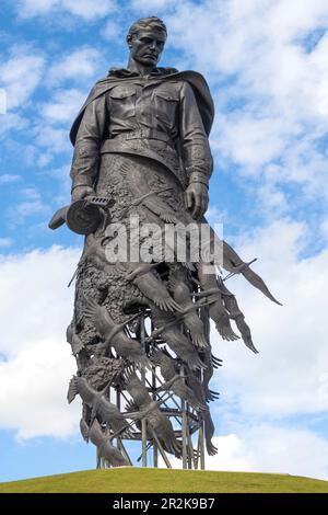 RZHEV, RUSSIA - 15 LUGLIO 2022: Scultura di un soldato addolente primo piano contro un cielo nuvoloso blu. Memoriale in onore di tutti i soldati sovietici morti Foto Stock