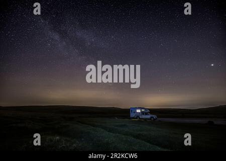 Furgone da camper lonely lit, furgone da camper di notte sotto il cielo stellato, via lattiginosa. Foto Stock