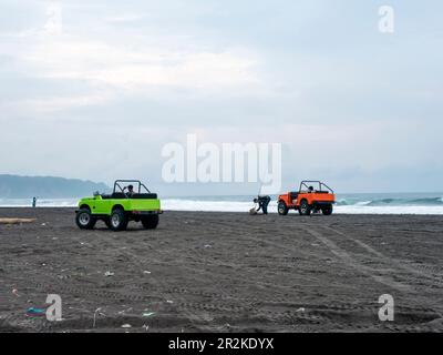 Auto colorate per turisti sulla spiaggia di Parangtritis, Yogyakarta, Indonesia Foto Stock