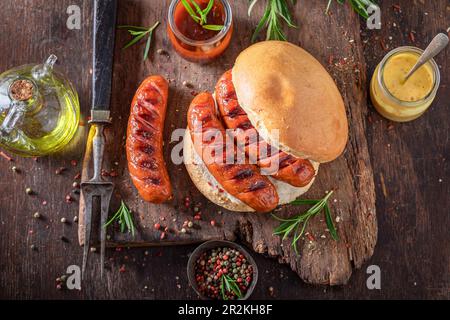 Gustoso panino con salsiccia arrosto di maiale. Salsiccia alla griglia con spezie. Foto Stock