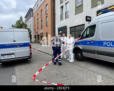 Berlino, Germania. 20th maggio, 2023. La polizia e la medicina legale sono sulla scena. Un uomo è stato ucciso a Berlino-Hellersdorf. Secondo la polizia di Berlino, è stato trovato gravemente ferito sul marciapiede di fronte a un bar su Janusz-Kornzak-Strasse presto Sabato mattina. La polizia assume un omicidio, ha detto un portavoce della polizia. L'uomo era apparentemente stato ferito con un oggetto appuntito, ha detto. I tentativi di risuscitarlo non hanno avuto successo. Credit: Dominik Totaro/TNN/dpa/Alamy Live News Foto Stock