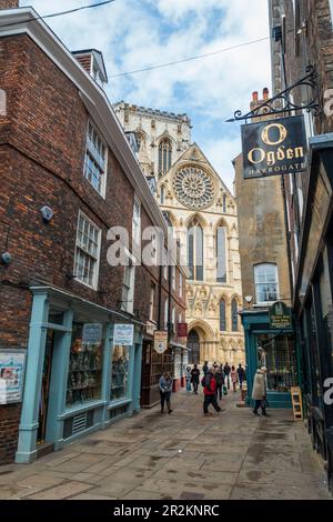 York Minster e negozi su Minster Gates visto dalla Stonegate a York, North Yorkshire, Inghilterra, Regno Unito Foto Stock