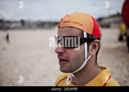 Un bagnino che indossa il loro caratteristico cappello, in servizio alla spiaggia di Bondi, a Sydney, Australia. Foto Stock