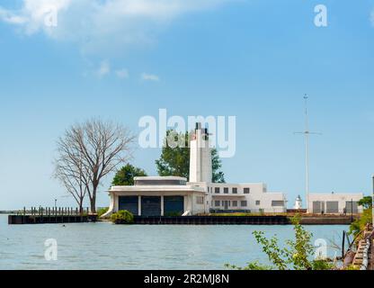 La vecchia stazione della Guardia Costiera abbandonata sul lago Erie a Cleveland, Ohio, con il faro in lontananza Foto Stock