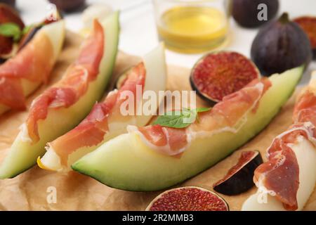 Gustosi meloni, jamon e fichi serviti su pergamena, primo piano Foto Stock