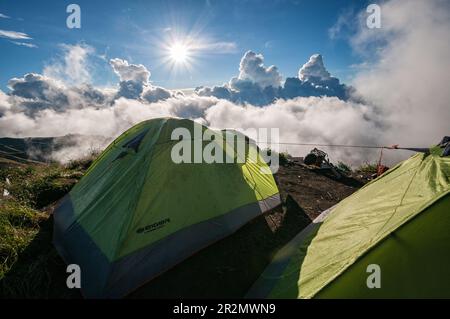 Tende e sole al campo sul bordo del cratere di Senaru sul Monte Rinjani, Lombok, Indonesia Foto Stock