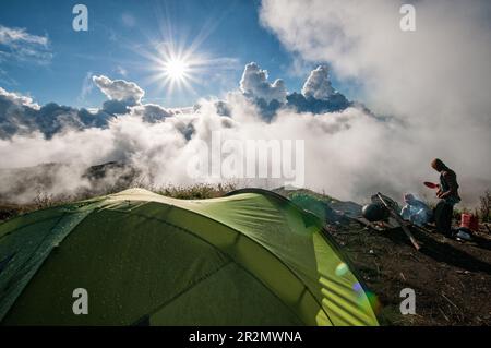 Sole e nuvole al bordo del cratere del campo di Senaru sul Monte Rinjani, Lombok, Indonesia Foto Stock