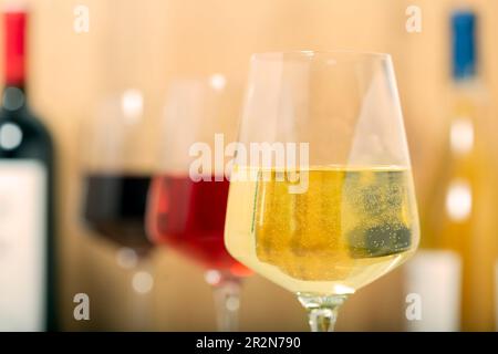 Esperienza di degustazione nella cantina rustica e nel wine bar: Bicchiere di vino rosso, bianco e rosato e collezione di vini pregiati sullo sfondo Foto Stock