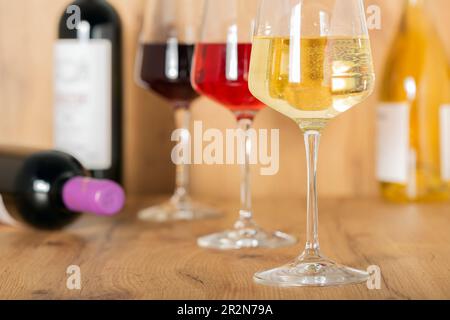 Esperienza di degustazione nella cantina rustica e nel wine bar: Bicchiere di vino rosso, bianco e rosato e collezione di vini pregiati sullo sfondo Foto Stock