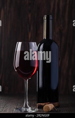 Bottiglia di vino rosso e cavatappi su un vecchio tavolo di legno Foto Stock