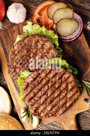 Cotolette di carne fresca su sfondo di legno Foto Stock